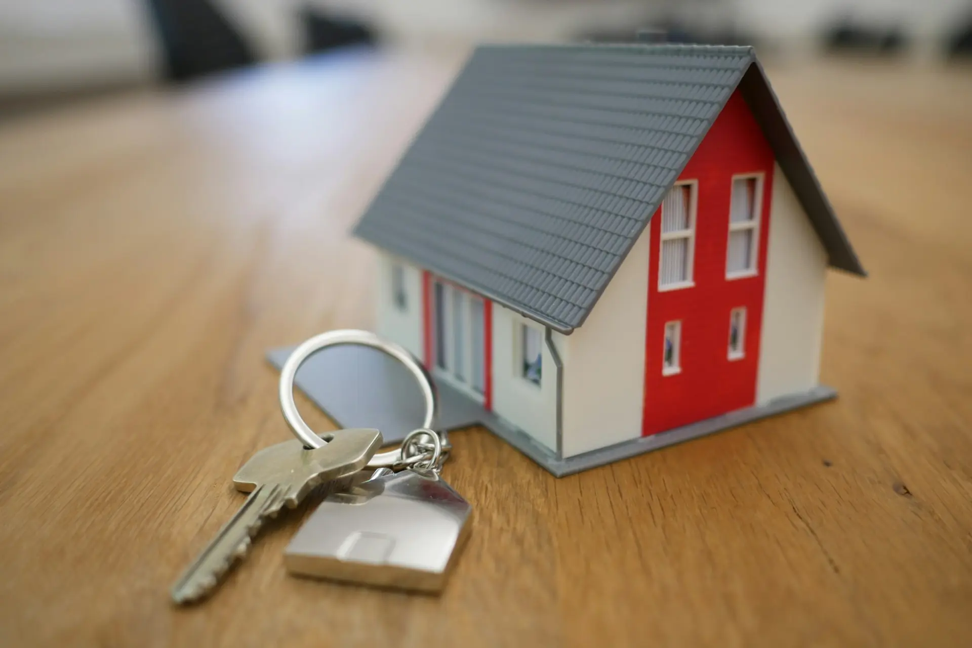 white and red wooden house miniature on brown table